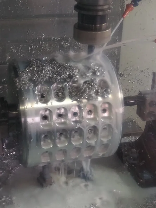 Pieza de aluminio en un centro CNC, con refrigerante