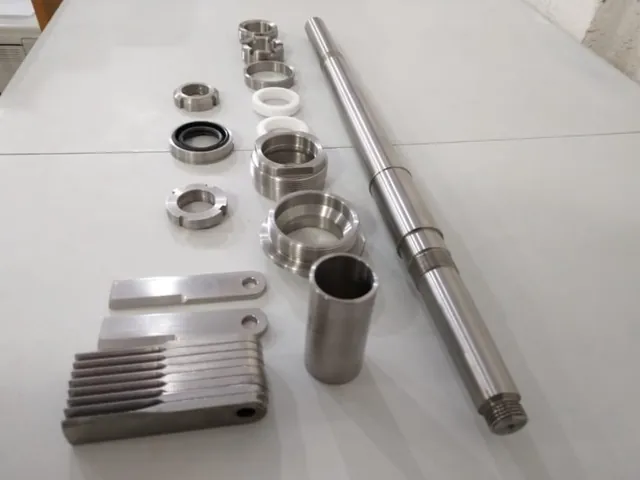 Flecha, anillos y piezas torneadas sobre mesa blanca